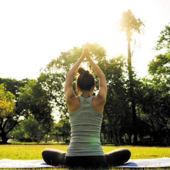 Young asian woman yoga outdoors keep calm and meditates while pr